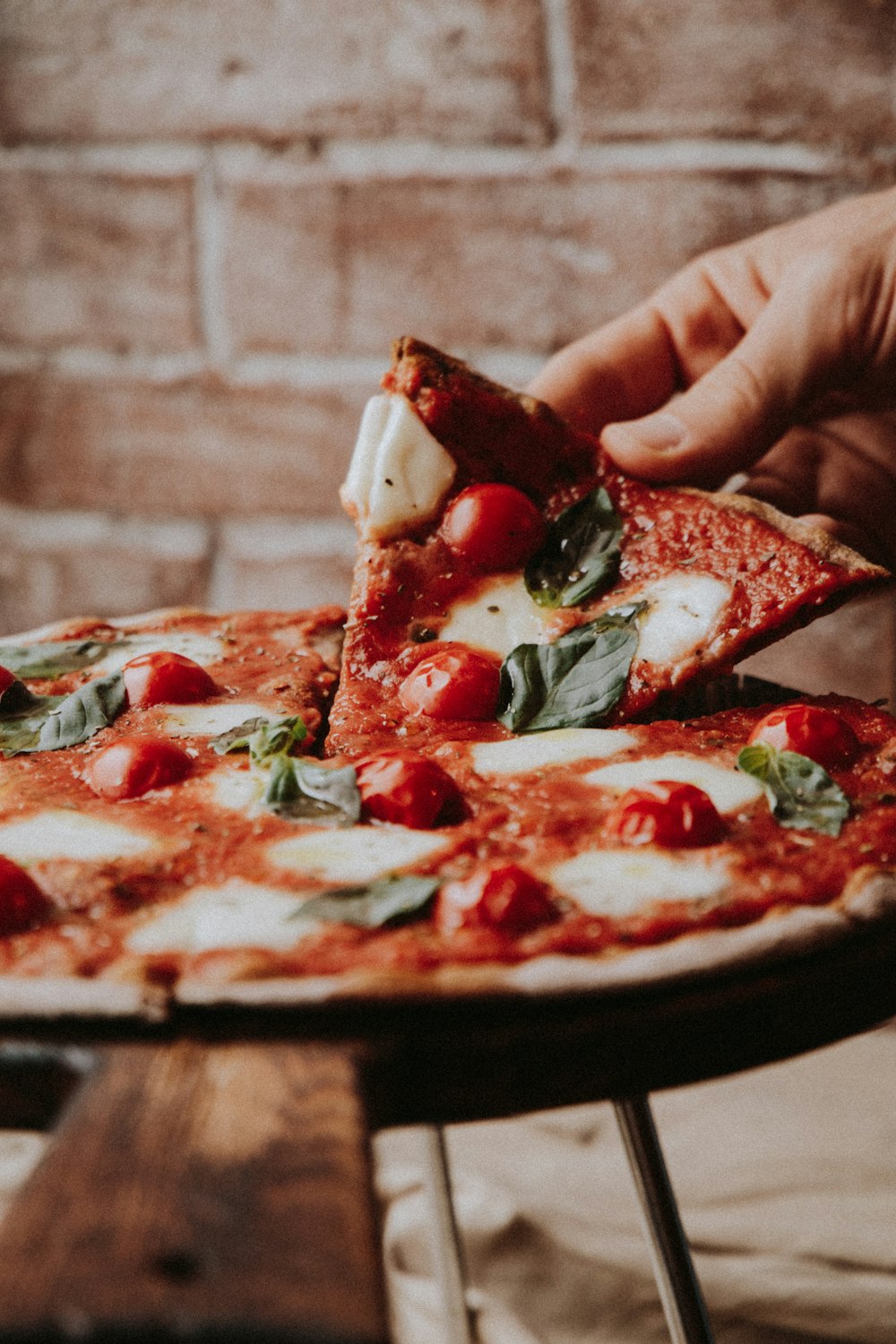 Una fetta di pizza al pomodoro, mozzarella, pomodorini e basilico